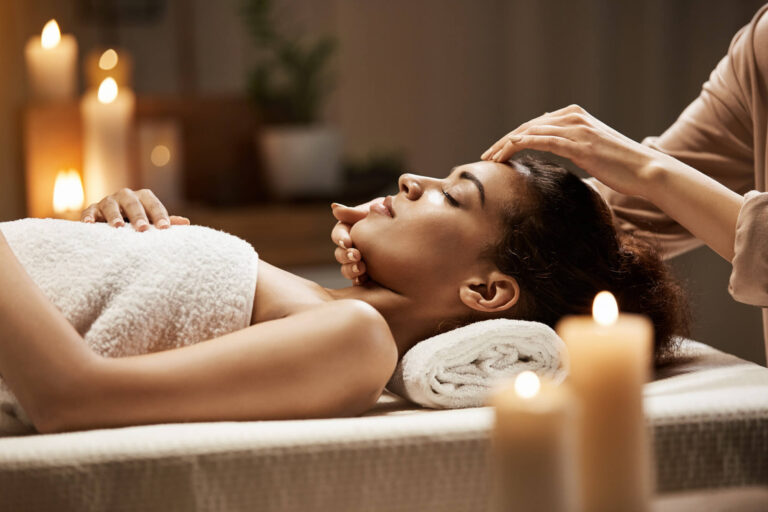 attractive african woman enjoying face massage spa salon